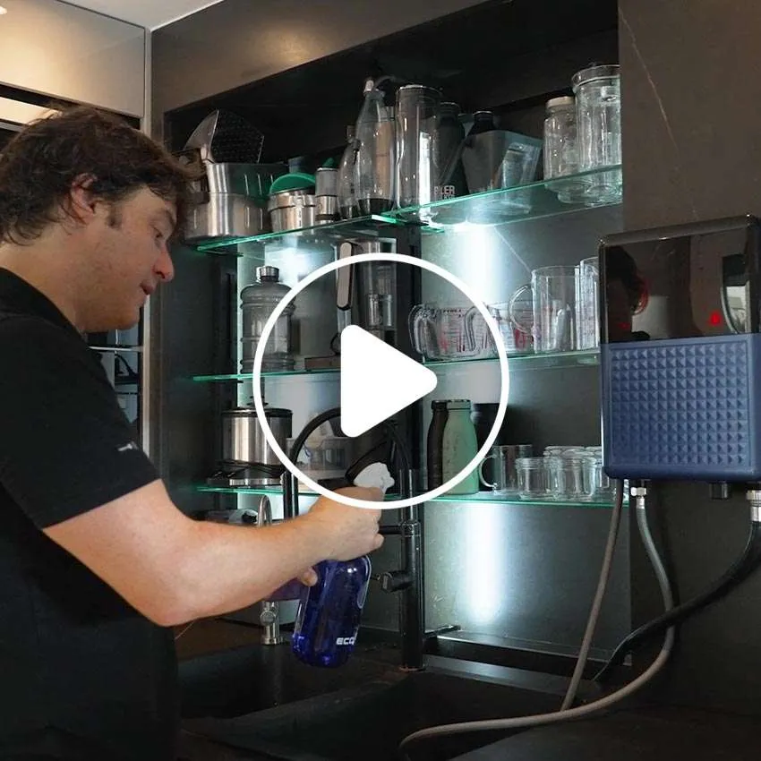 Jordi Cruz filling a spray bottle at a kitchen sink